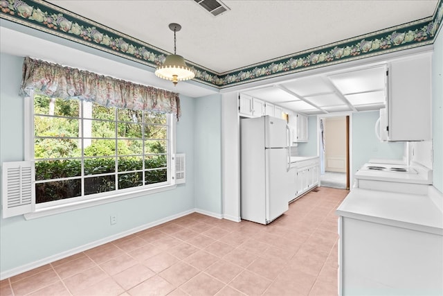 kitchen featuring light tile patterned floors, a textured ceiling, white cabinets, and white fridge