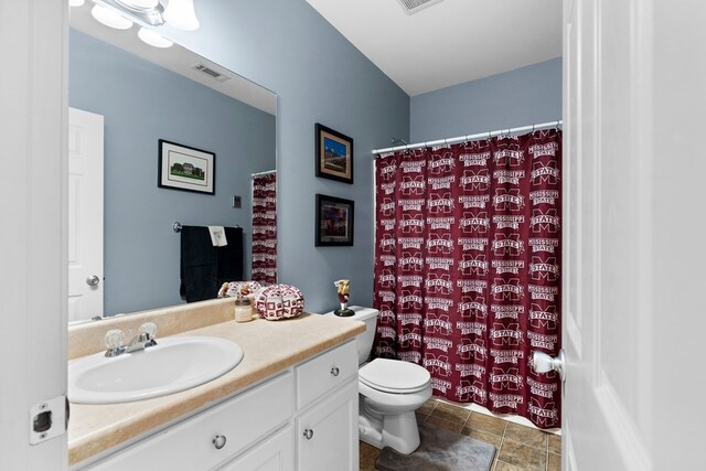 full bathroom featuring a shower with shower curtain, visible vents, toilet, and vanity