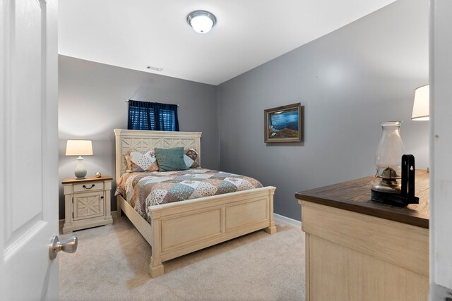 bedroom with baseboards and light colored carpet