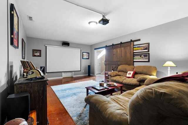 home theater room with a barn door, baseboards, and visible vents