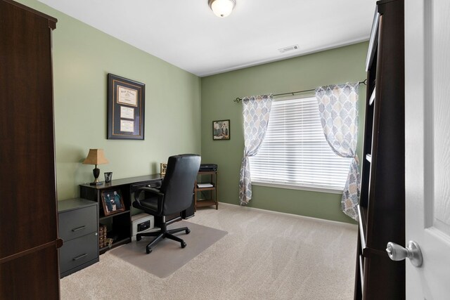 home office featuring visible vents, baseboards, and light colored carpet