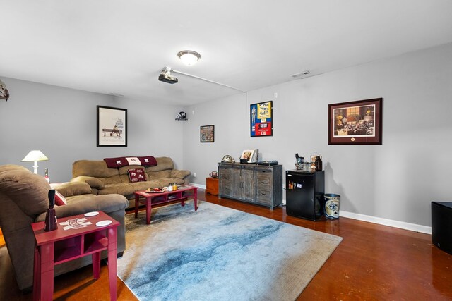 living area featuring baseboards, visible vents, and finished concrete floors