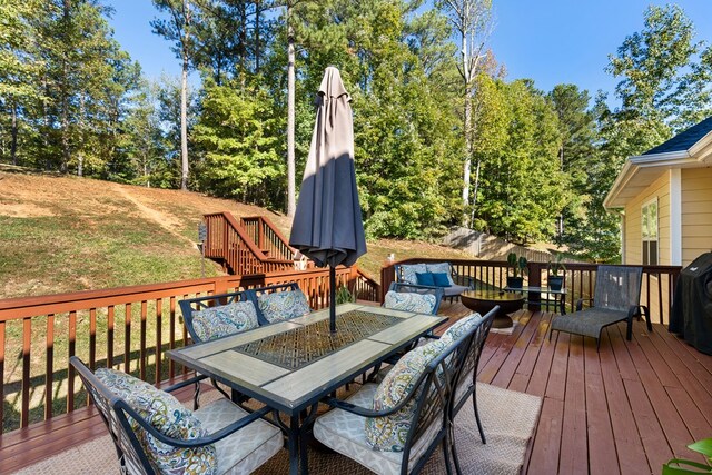 wooden terrace with outdoor dining area and a yard