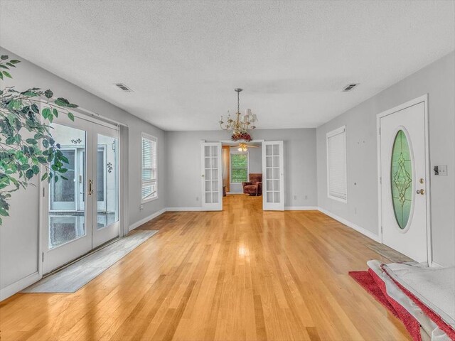 4978 Standifer Rd, Cohutta, GA 30710 - entryway featuring french doors, light wood-style floors, a chandelier, baseboards, and a textured ceiling