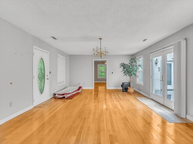 4978 Standifer Rd, Cohutta, GA 30710 - foyer entrance featuring a textured ceiling, light wood finished floors, french doors, a chandelier, and baseboards