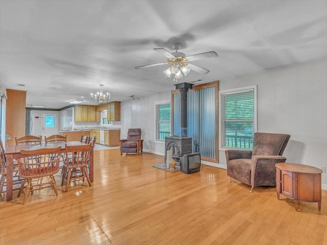4978 Standifer Rd, Cohutta, GA 30710 - dining room featuring a wood stove, light wood-style flooring, a ceiling fan, a chandelier, and baseboards