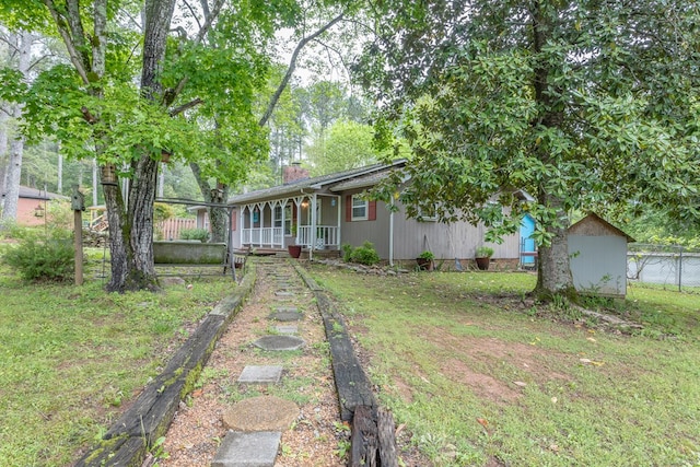 view of yard with covered porch and fence