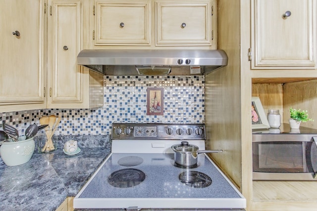 kitchen with electric range oven, cream cabinets, decorative backsplash, and under cabinet range hood