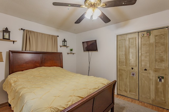 bedroom with light wood-style floors, a closet, and a ceiling fan
