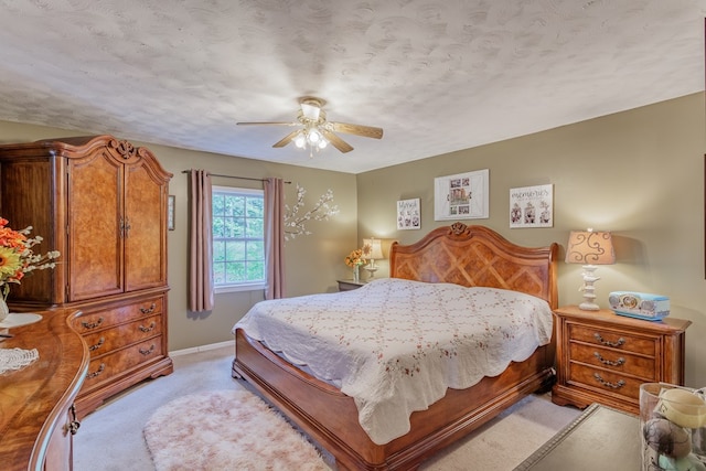 bedroom featuring light colored carpet, baseboards, and a ceiling fan