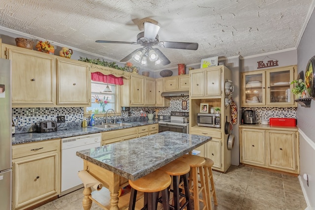 kitchen featuring light brown cabinetry, stainless steel appliances, and a sink
