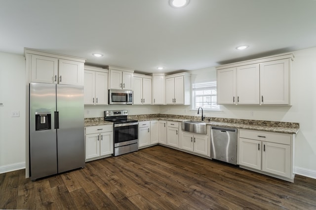 111 Arthur St, Dalton, GA 30721 - kitchen featuring appliances with stainless steel finishes, a sink, dark wood-style floors, white cabinets, and light stone counters