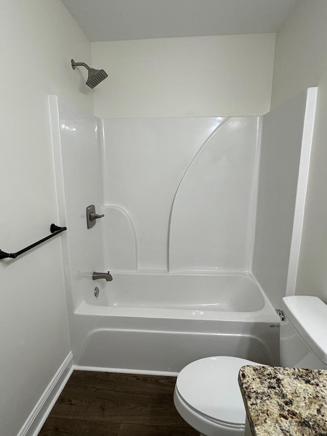 full bath featuring  shower combination, baseboards, toilet, and wood finished floors