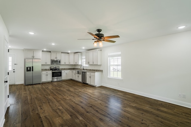 111 Arthur St, Dalton, GA 30721 - kitchen with stainless steel appliances, baseboards, dark wood finished floors, a ceiling fan, and white cabinetry