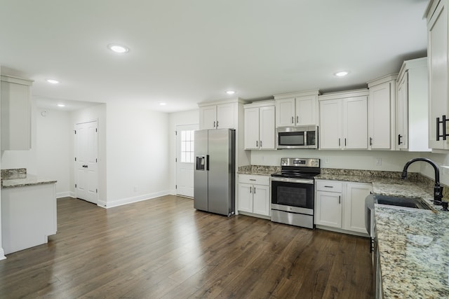 111 Arthur St, Dalton, GA 30721 - kitchen featuring appliances with stainless steel finishes, a sink, dark wood-style flooring, light stone countertops, and white cabinetry