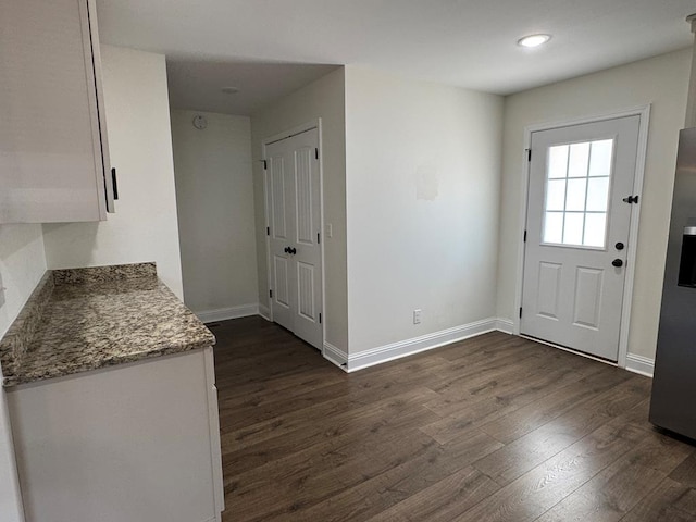 doorway to outside featuring dark wood-style floors and baseboards