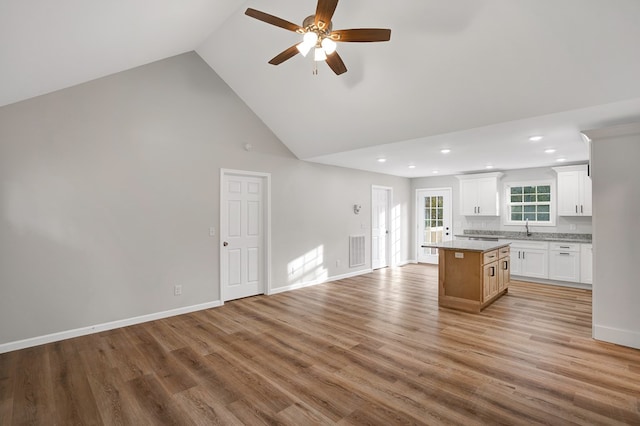 kitchen featuring white cabinetry, a kitchen island, sink, and light hardwood / wood-style flooring