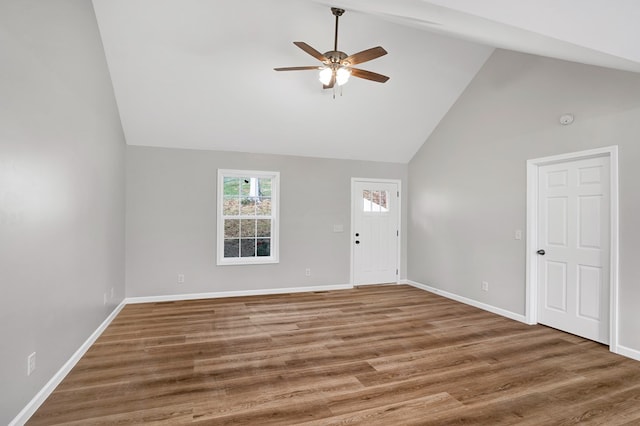 unfurnished living room featuring high vaulted ceiling, dark wood-type flooring, and ceiling fan