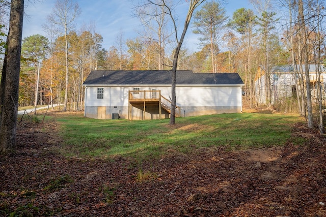 rear view of property with a wooden deck and a lawn