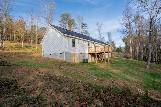 back of house with a wooden deck, central AC, and a lawn