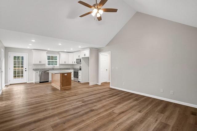 kitchen featuring a kitchen island, high vaulted ceiling, white cabinetry, hardwood / wood-style flooring, and stainless steel appliances