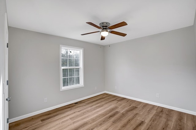 empty room with ceiling fan and light hardwood / wood-style flooring