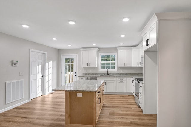 kitchen featuring white cabinetry, appliances with stainless steel finishes, a center island, and sink