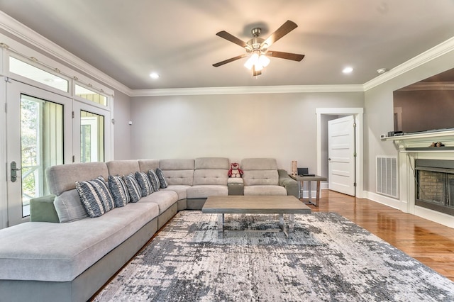 living room featuring hardwood / wood-style flooring, crown molding, and ceiling fan