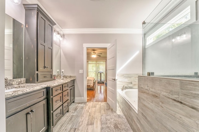 bathroom featuring hardwood / wood-style floors, ornamental molding, tiled bath, and vanity