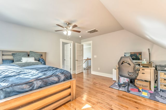 bedroom with hardwood / wood-style flooring, vaulted ceiling, and ceiling fan