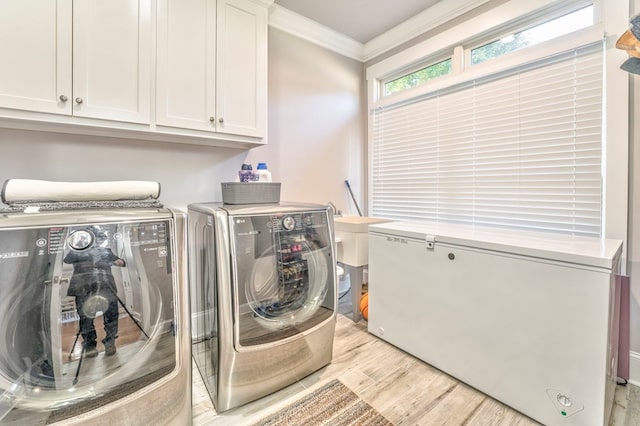 washroom featuring cabinets, crown molding, light hardwood / wood-style flooring, and washer and dryer