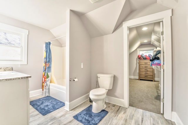 full bathroom with lofted ceiling, vanity, wood-type flooring, toilet, and shower / bath combo with shower curtain