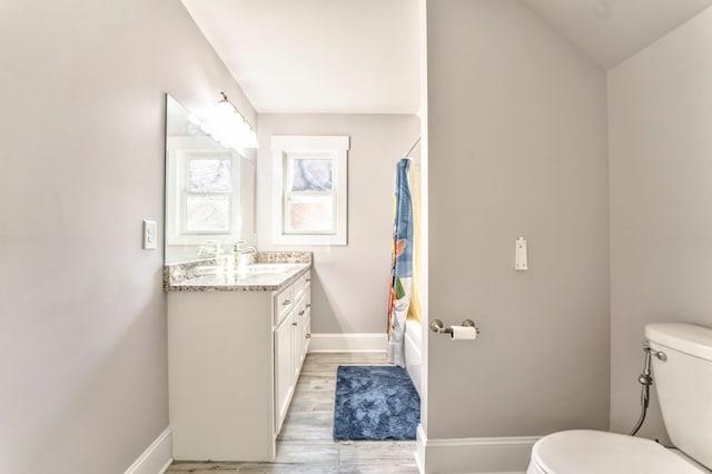 full bathroom with vanity, hardwood / wood-style flooring, toilet, and shower / bath combo with shower curtain