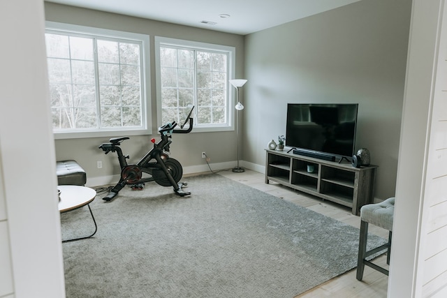 exercise room with baseboards and visible vents