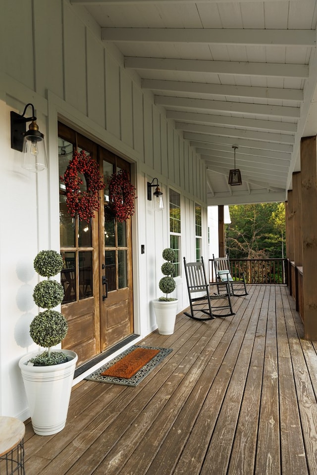 wooden deck featuring covered porch and french doors