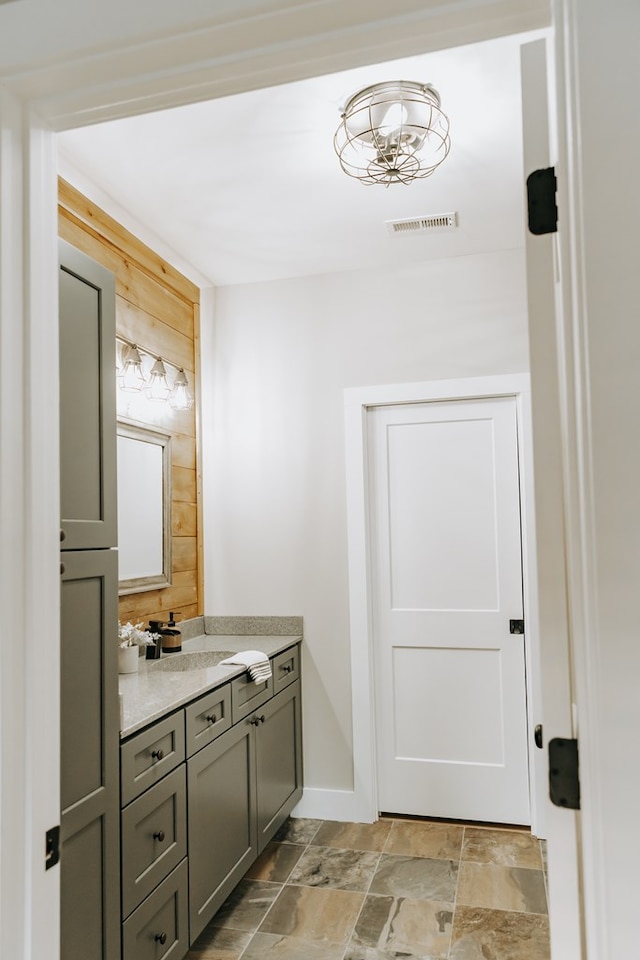 bathroom with vanity, visible vents, and stone finish floor