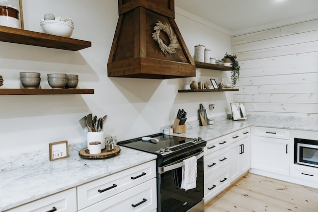 kitchen featuring light stone countertops, white cabinetry, open shelves, light wood-style floors, and appliances with stainless steel finishes