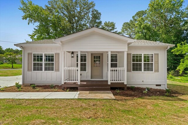 500 Woodland Dr, Dalton, GA 30721 - view of front of property with board and batten siding, covered porch, and a front lawn