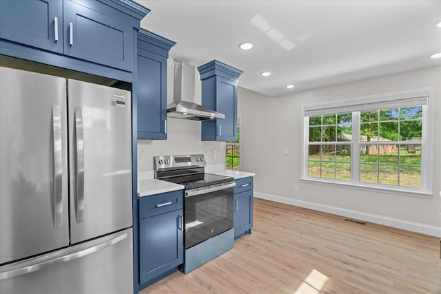 500 Woodland Dr, Dalton, GA 30721 - kitchen with stainless steel appliances, wall chimney exhaust hood, light countertops, blue cabinets, and light wood finished floors