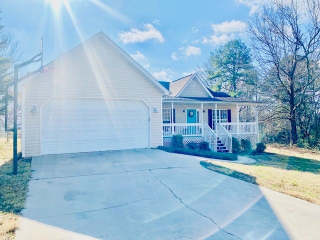 view of front of home featuring a porch, a garage, and a front lawn