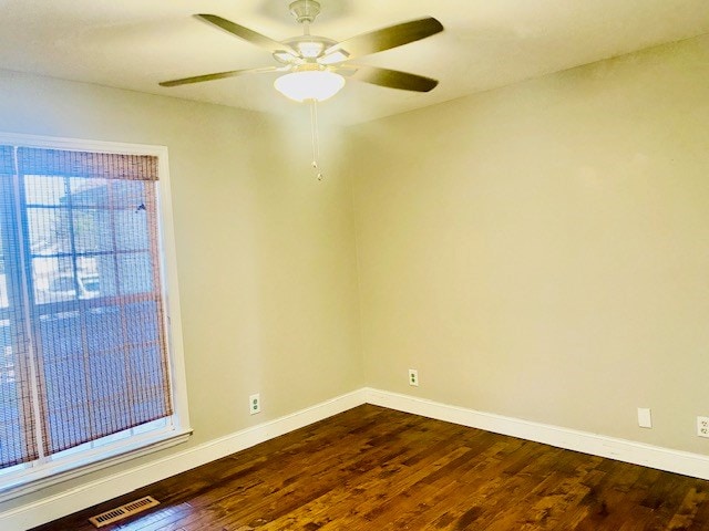 empty room featuring dark wood-type flooring and ceiling fan