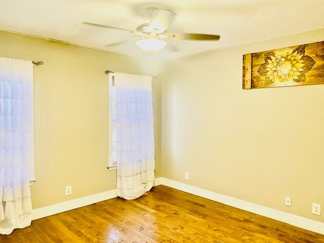 empty room with ceiling fan and wood-type flooring