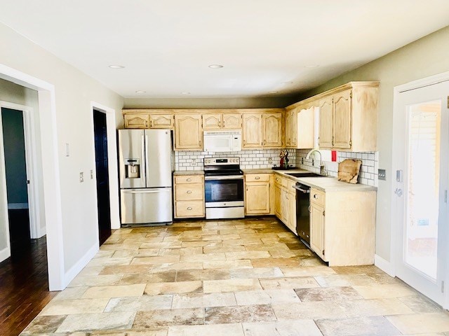 kitchen featuring stainless steel appliances, tasteful backsplash, sink, and light brown cabinetry