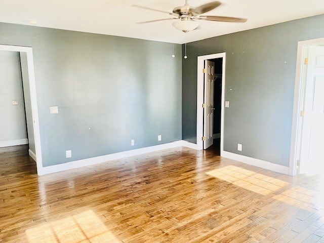 empty room with ceiling fan and light hardwood / wood-style floors