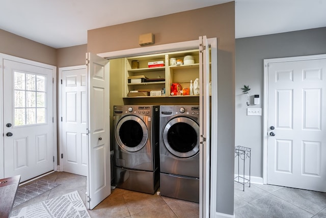 laundry area with separate washer and dryer and light tile patterned floors