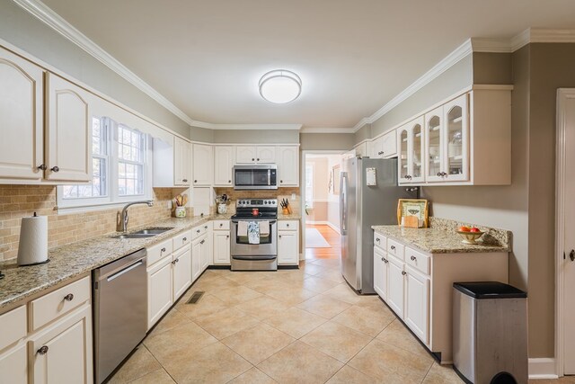 816 Dogwood Ln, Dalton, GA 30720 - kitchen with stainless steel appliances, a sink, backsplash, light stone counters, and glass insert cabinets