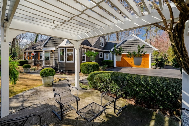 view of patio with a garage and a pergola