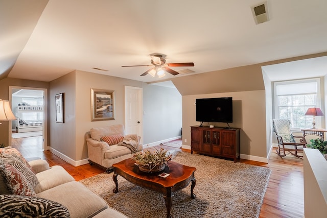 living room with ceiling fan, lofted ceiling, and light wood-type flooring