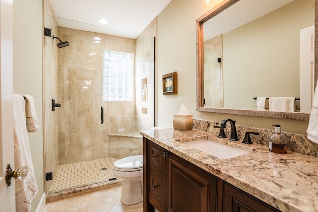 bathroom with vanity, tile patterned floors, a shower with door, and toilet