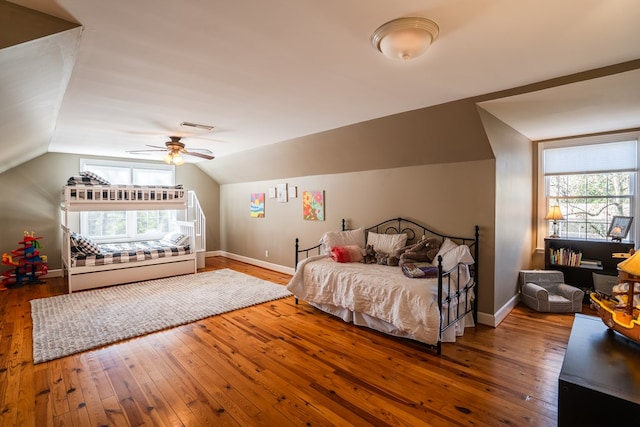 bedroom featuring hardwood / wood-style flooring, lofted ceiling, and multiple windows